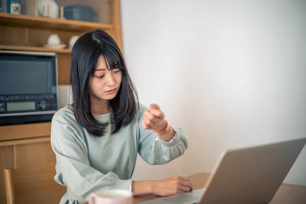 自宅で手持ち無沙汰に待つ女性
