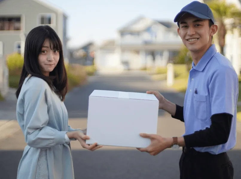 玄関先で荷物を受け渡すスタッフと顧客