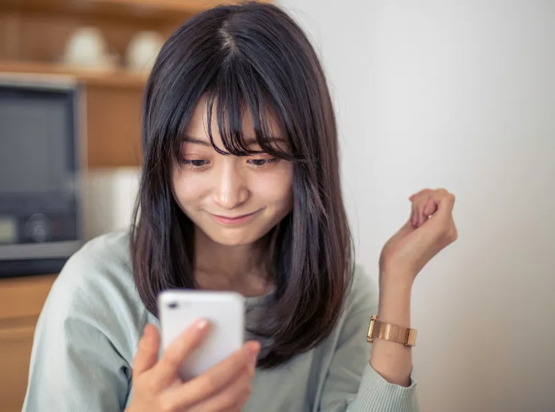 届いた SMS をスマートフォンで開く女性